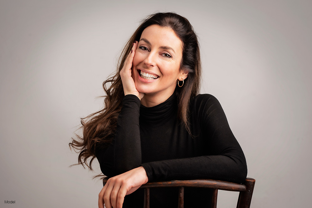 Mature woman in a long black shirt sitting on a chair